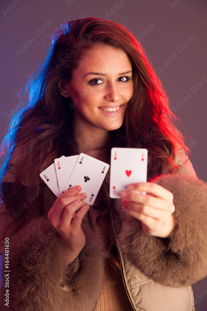 Beautiful brunette holding four aces as a sign for poker game, gambling and casino Beautiful brunette holding four aces as a sign for poker game, gambling and casino