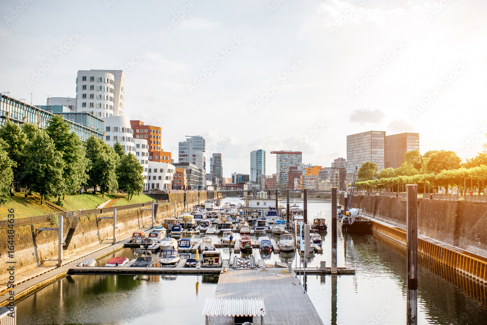 Sunset cityscape view on the modern district at the media harbour with beautiful buildings and boats in Dusseldorf city in Germany