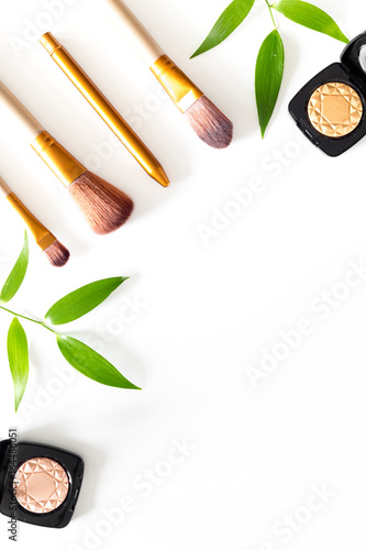 Makeup tools. Brushes and eyeshadows on white table background top view copyspace