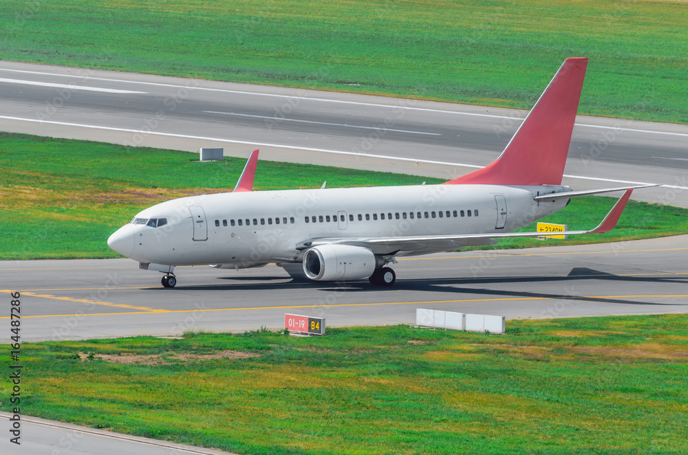 Aiplane on the runway after landing, taxiing to the terminal at the airport Aiplane on the runway after landing, taxiing to the terminal at the airport