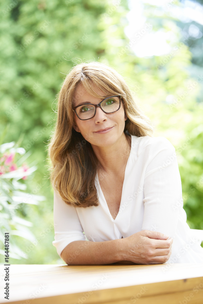 Be positive. A confident mid age woman sitting on garden terrace