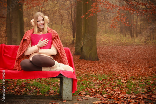 Blonde girl reading book in autumn scenery