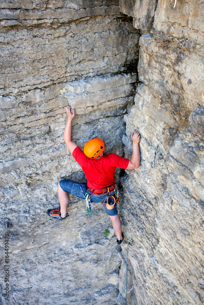 Climber in a helmet climbs up. Climber in a helmet climbs up.