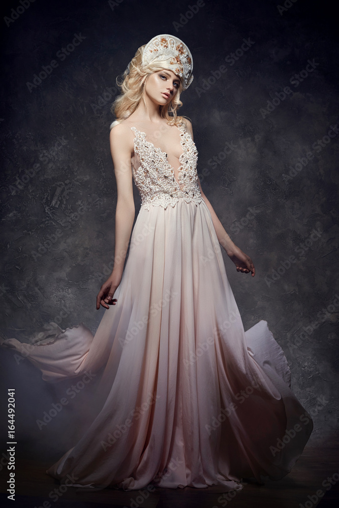 Tiara crown on head blonde girl. Woman in fairy dress, mysterious magical fairy. Ethnic blond woman on gray background Tiara crown on head blonde girl. Woman in fairy dress, mysterious magical fairy. Ethnic blond woman on gray background