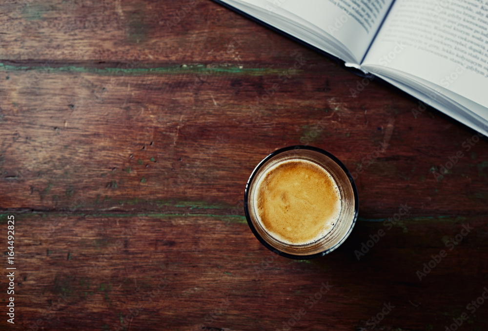 Glass of Espresso and a Book on an old Wooden Table Glass of Espresso and a Book on an old Wooden Table