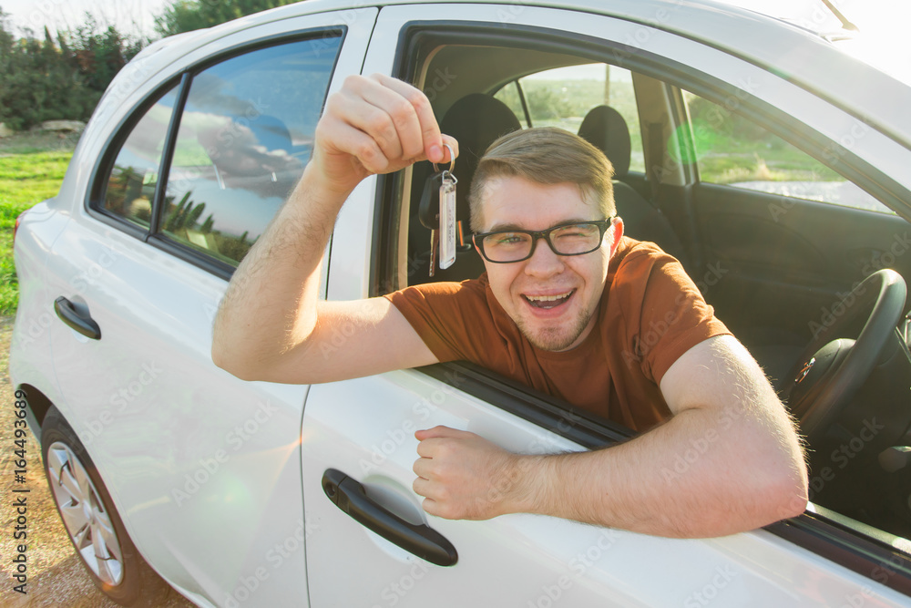 Naklejka premium Happy man showing the key of his new car