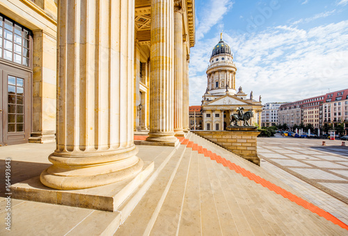 Viiew on the columns of the concert house building with German cathedral on the background during the morning light in Berlin city photo