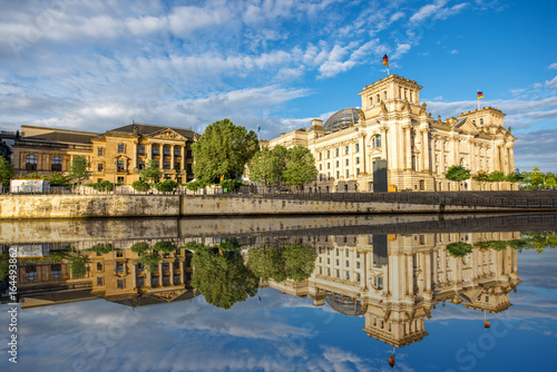 Morning cityscape view on the famous Reichstag building with beautiful reflection in the water in Berlin city
