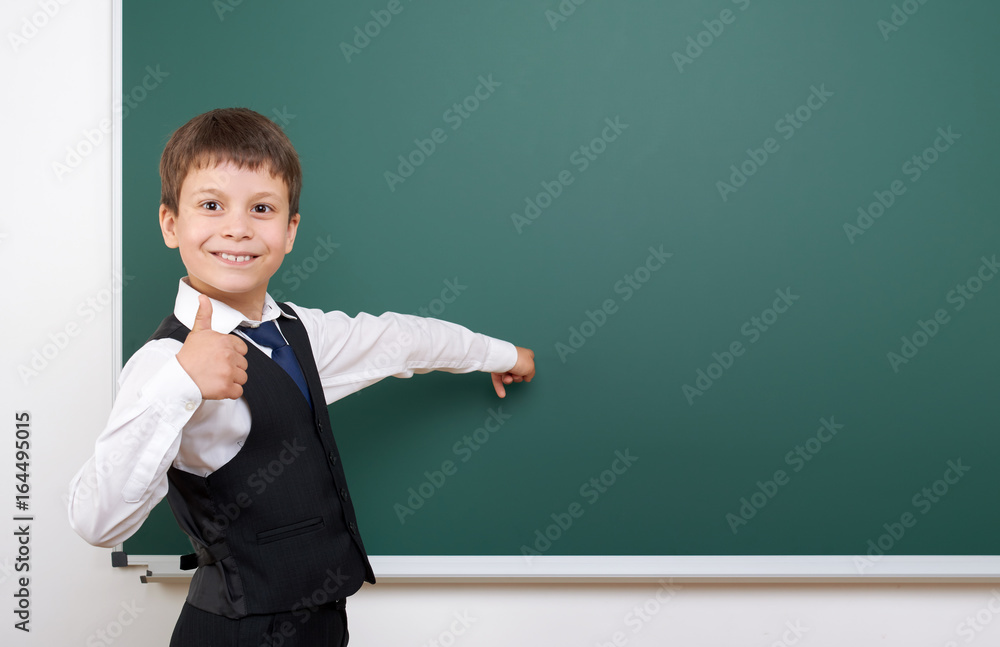 Pupil posing at school board, empty space, education concept Pupil posing at school board, empty space, education concept