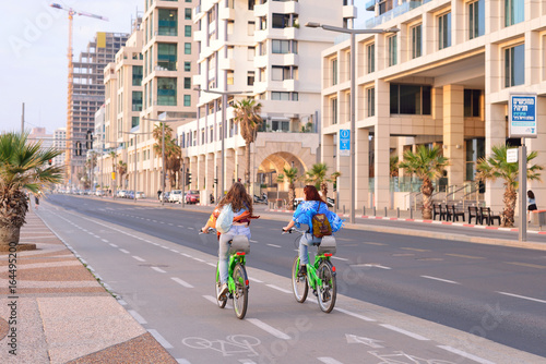 TEL AVIV, ISRAEL- APRIL, 2017: Herbert Samuel st. bike track and walking area for pedestrians in the center of Tel Aviv. Girls ride bicycles on holiday