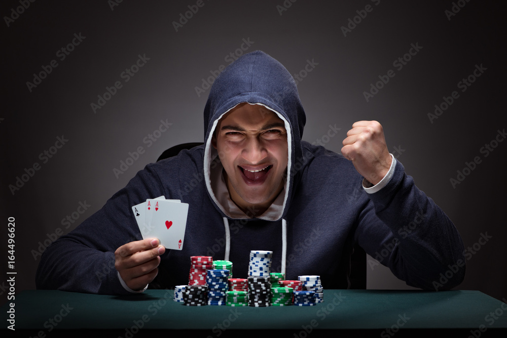 Young man wearing a hoodie with cards and chips gambling Young man wearing a hoodie with cards and chips gambling