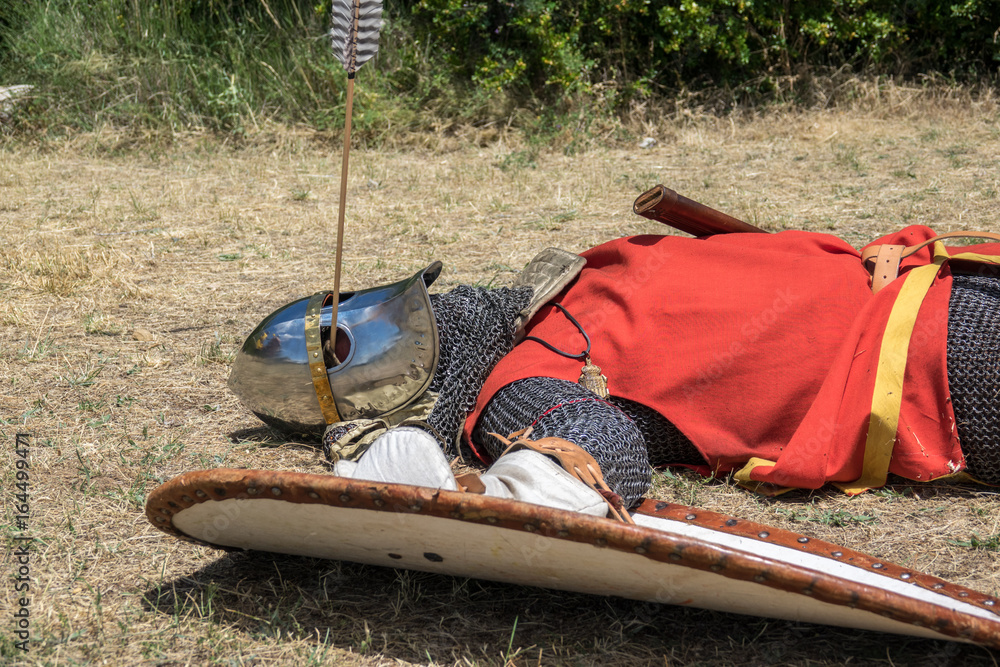 Medieval knight fallen in battle, with an arrow piercing his helmet and