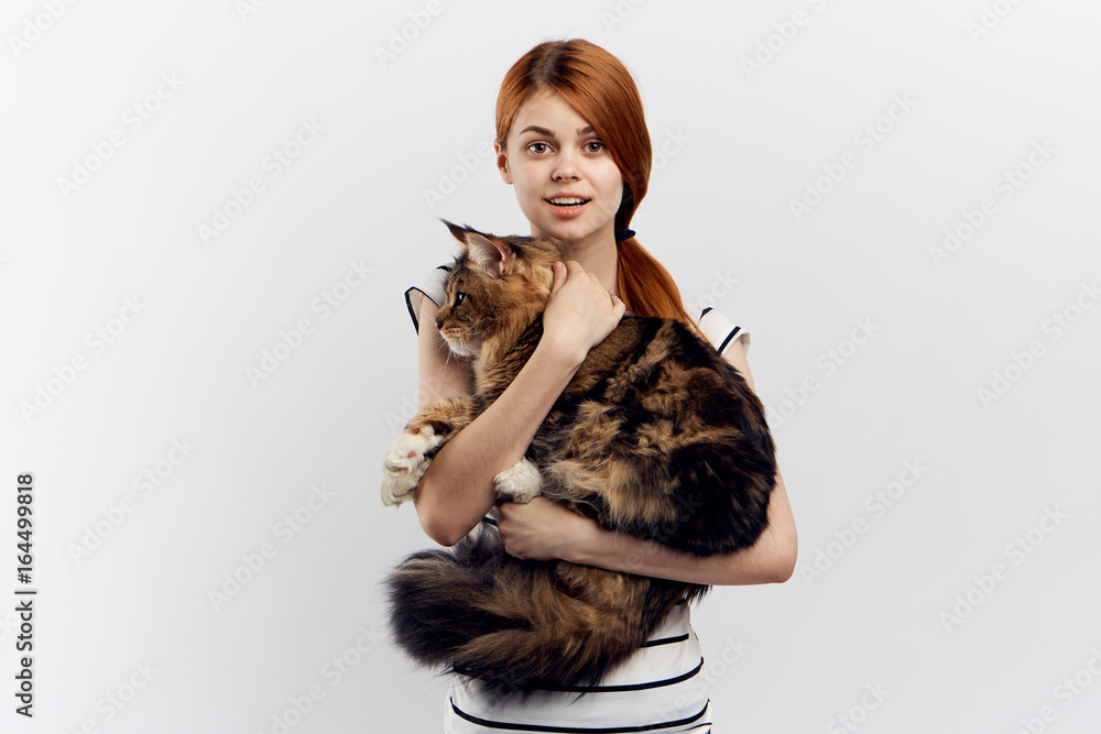 Beautiful young woman on white isolated background holds a cat