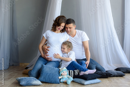 Pregnant family with child girl Spend time together at home. A happy family is waiting for the birth of a newborn baby 