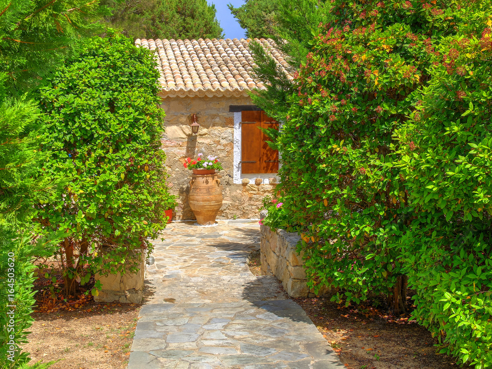 View on family Greece traditional Greek village style hotel entrance green gate, antique classical vase jar flowers. Gingerbread Classic Greece architecture Greece holidays vacations sightseeing tours View on family Greece traditional Greek village style hotel entrance green gate, antique classical vase jar flowers. Gingerbread Classic Greece architecture Greece holidays vacations sightseeing tours