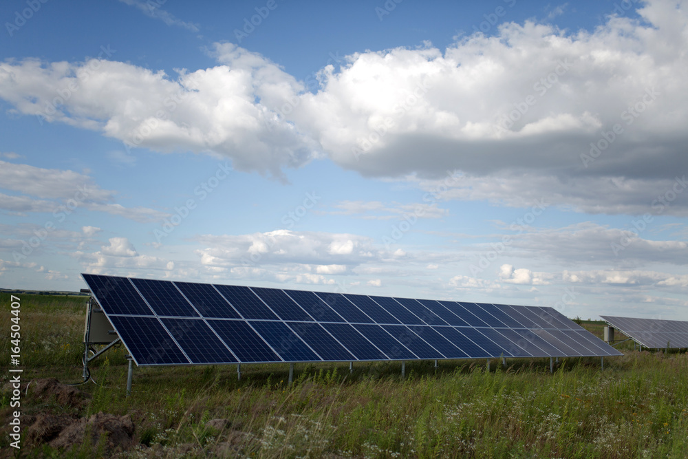 Fototapeta premium Solar energy panels in the field. View on a equipment on a solar energy power station.