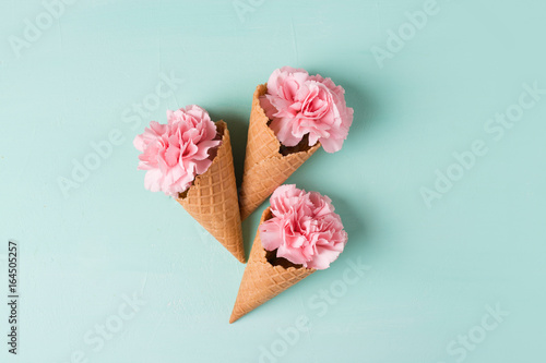 Pink carnations on a blue background. Flowers. Copyspace. Flower photo concept. Flowers in waffle cones