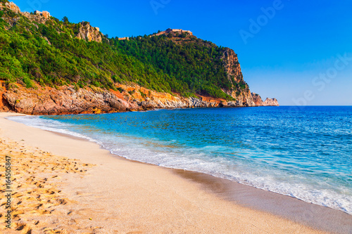 Photography Cleopatra beach on sea coast with green rocks in Alanya peninsula, Antalya district, Turkey