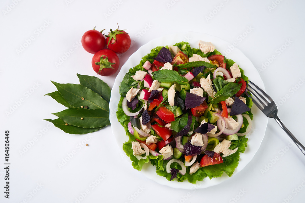 Fresh summer salad with fresh vegetables and greens on white background top view with space for text. Healthy food concept Fresh summer salad with fresh vegetables and greens on white background top view with space for text. Healthy food concept