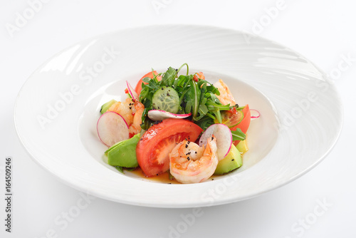 Creative salad with tiger shrimps, tomatoes, avocado and arugula.