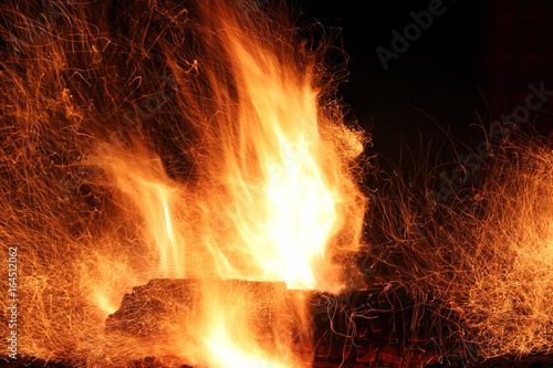 Bonfire flame on the black background. Vivid flame with traces of fire sparks. Beautiful nature abstract background. Danger concept.