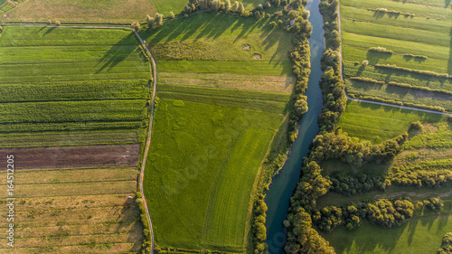 River bend surrounded by fields from bird's eye view. photo