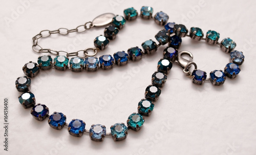 A beautiful blue and silver necklace with a white background