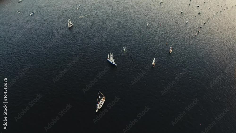 Aerial video of bay with floating sailing yacht fleet in marina during yachting regatta race shot from drone
