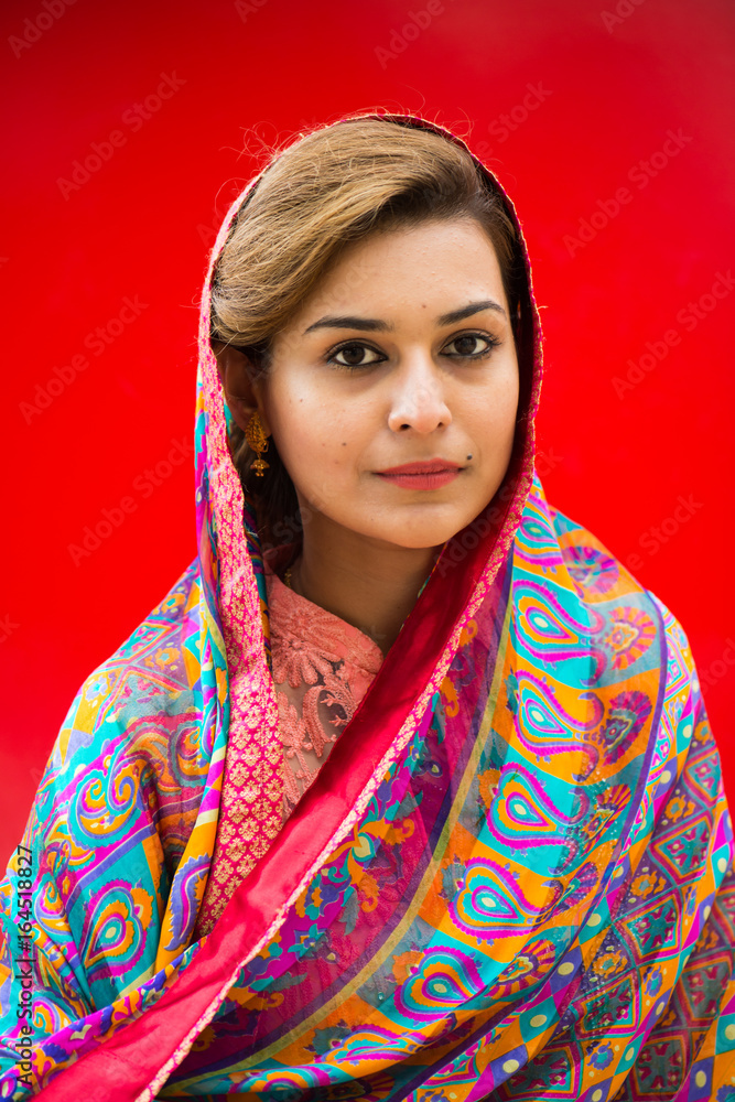 Pakistani minority woman in traditional clothing in front of a red background Pakistani minority woman in traditional clothing in front of a red background