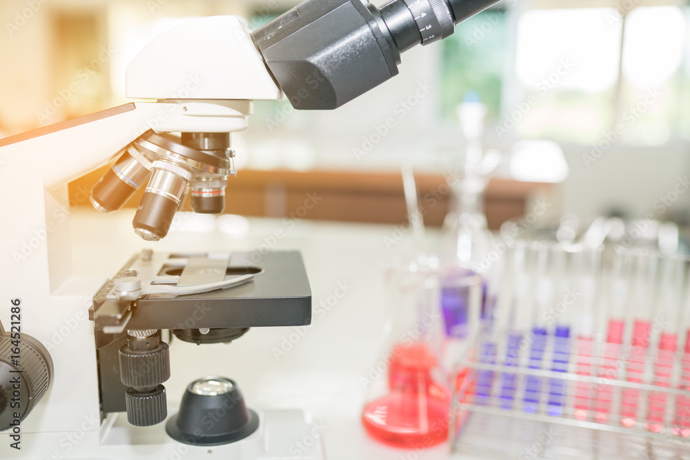 Microscope on the table in laboratory room with laboratory equipment Microscope on the table in laboratory room with laboratory equipment