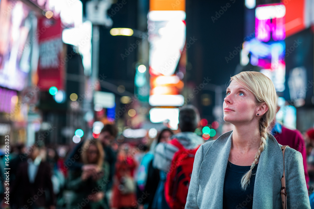 Naklejka premium Kobieta pod wrażeniem na środku Times Square w nocy,