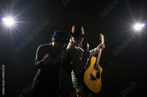 Fotografie Musician Duo band hand holding the microphone and singing a song and playing the