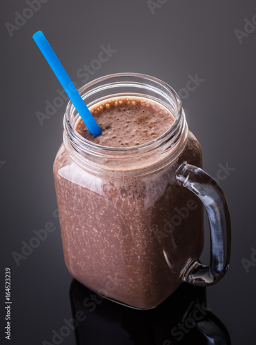 Milkshake chocolate in jar with a straw
