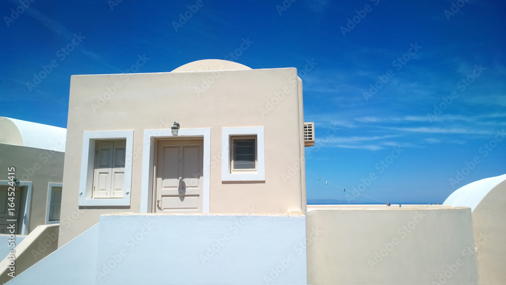 Light pink house in Oia on Santorini and a rope with clothespins for drying clothes next to it Light pink house in Oia on Santorini and a rope with clothespins for drying clothes next to it