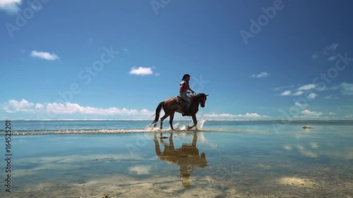 Cowboy man riding horse on shallow water at beach, Siargao, Philippines