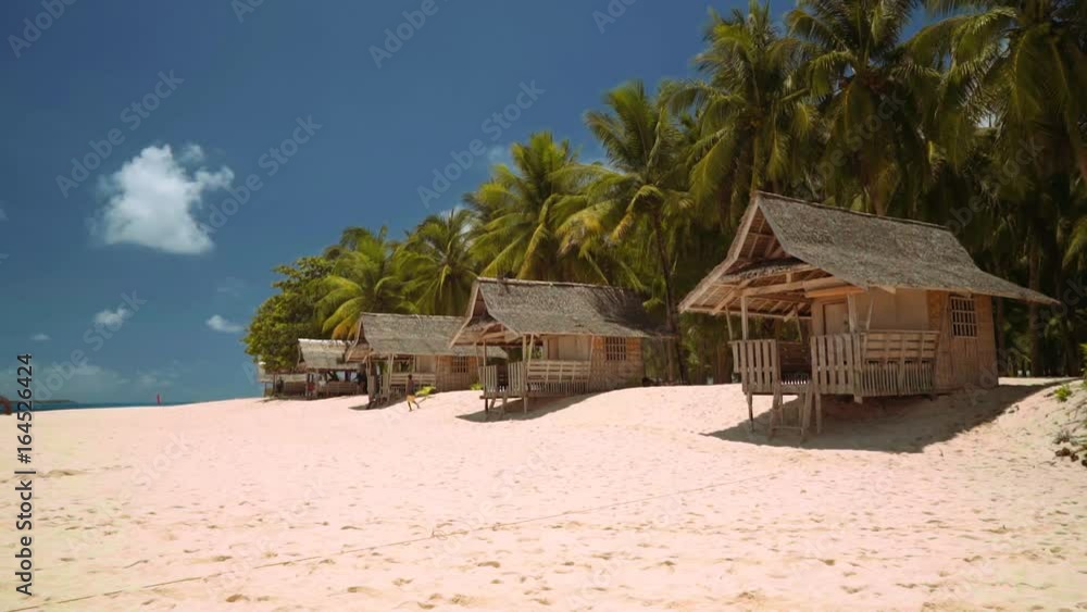 Small bungalows on white sand beach on tropical island - Daku Island, Philippines Small bungalows on white sand beach on tropical island - Daku Island, Philippines