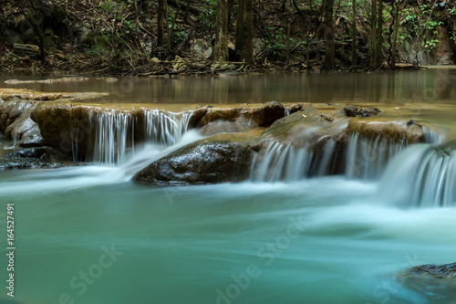 Small waterfall in the forest in summer. © noppharat