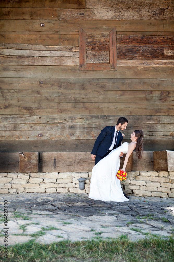 Happy groom holding her wife in their wedding day. Just married couple