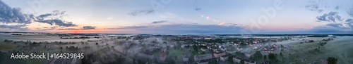 Aerial view of city in fog at amazing sunset. Summer nature landscape. Panorama.