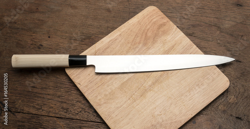 stainless steel kitchen Knife on wooden plate on wooden table from top view