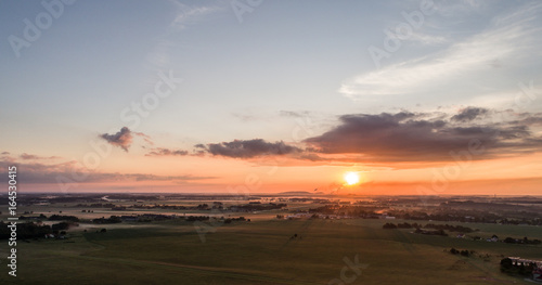 Aerial view of fields with fog at amazing sunset. Summer nature landscape. © nikwaller