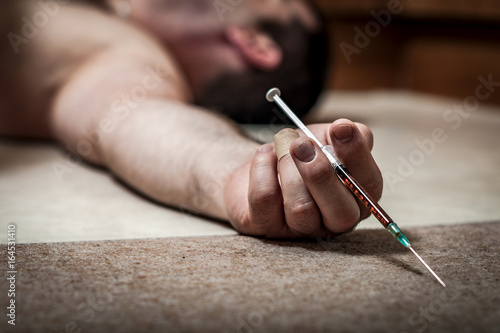 Photos Drug overdose and opioid epidemic concept with man lying naked on the floor in t