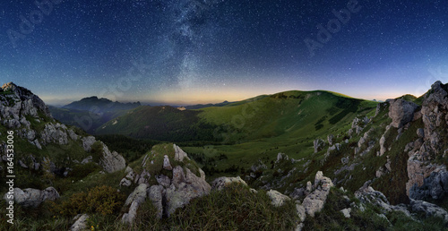 Milky way over green valley mountain