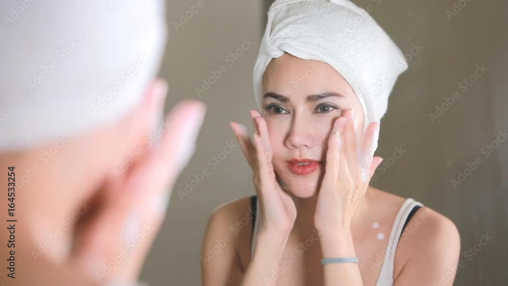 Woman cleaning washing her face with clean water in bathroom. Woman cleaning washing her face with clean water in bathroom.