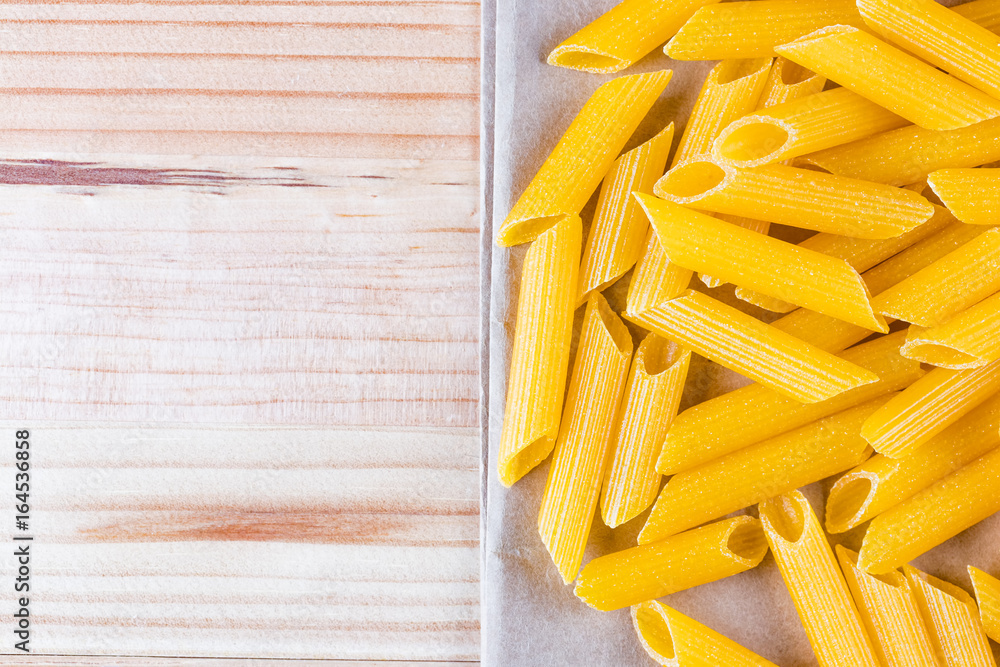Raw gluten free cannelloni pasta on a baking paper. Raw gluten free cannelloni pasta on a baking paper.