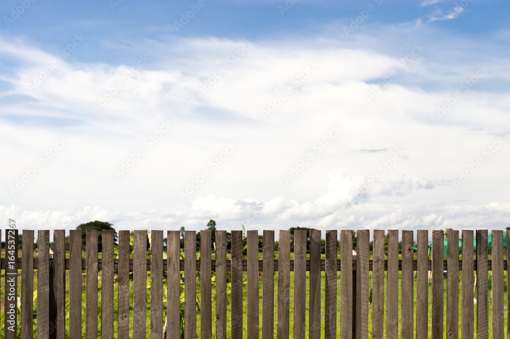Fototapeta premium Wooden fence and cloudy sky background.