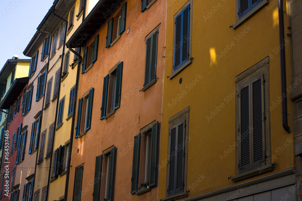 Naklejka premium Many windows. Medieval facade. Window shutters. Architectural style of Italy