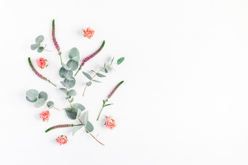 Flowers composition. Frame made of rose flowers and eucalyptus branches on white background. Flat lay, top view, copy space