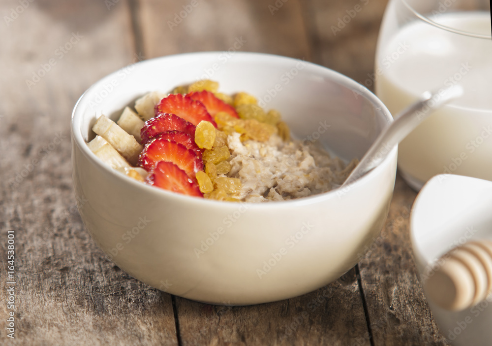 oatmeal porridge with strawberry and banana in wood bowl oatmeal porridge with strawberry and banana in wood bowl