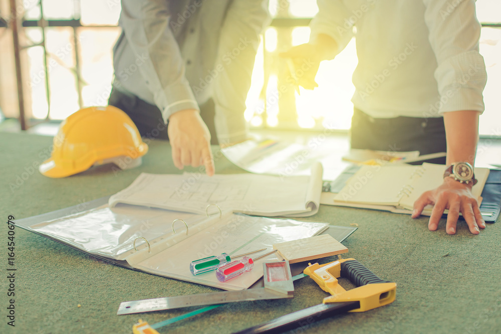architect, contractor and engineer discuss at a construction site, Architecture and Engineering concept. tools select focus architect, contractor and engineer discuss at a construction site, Architecture and Engineering concept. tools select focus